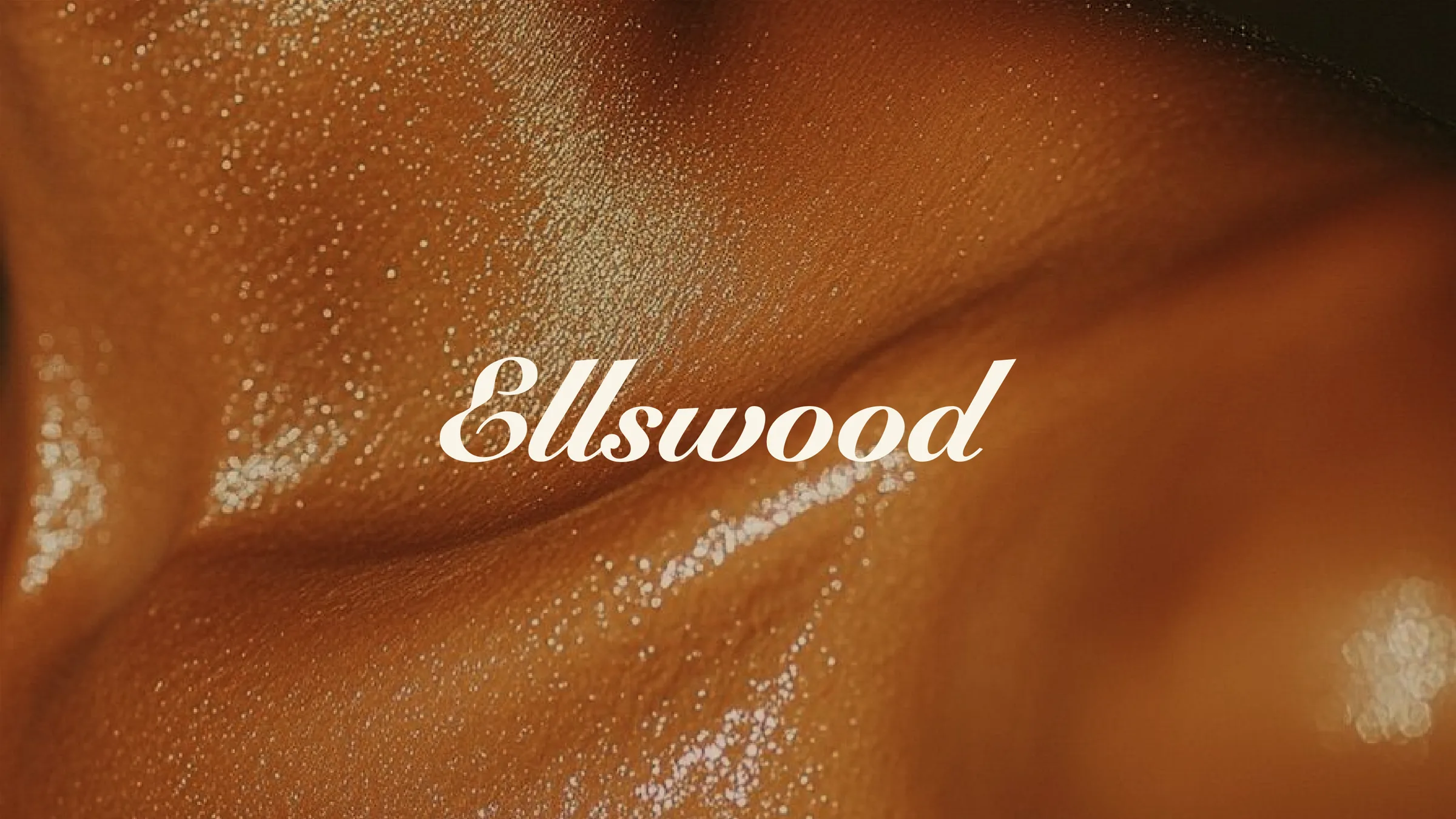 The Ellswood script wordmark in Silk, over a close-up of warm, glowing skin